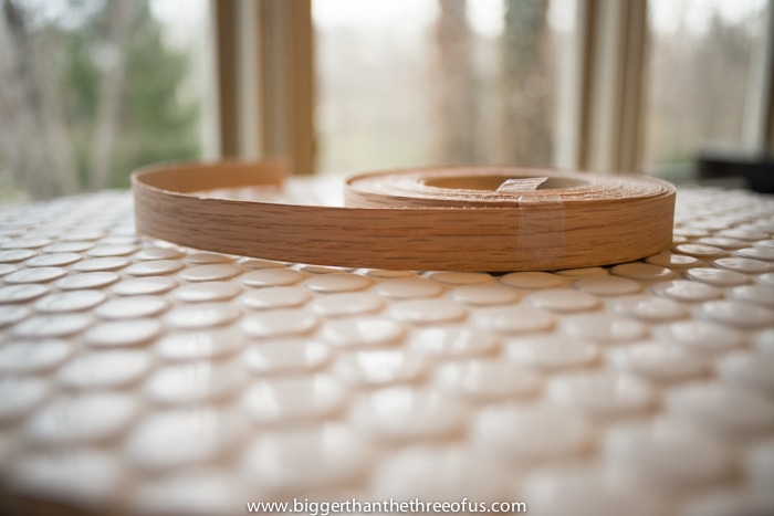Using wood veneer strips to circle the table top to create a nice edge