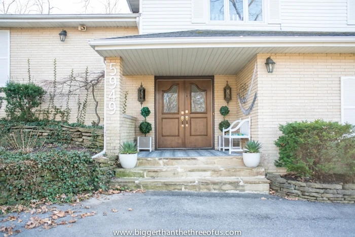 Covered porch with wood doors and cream brick