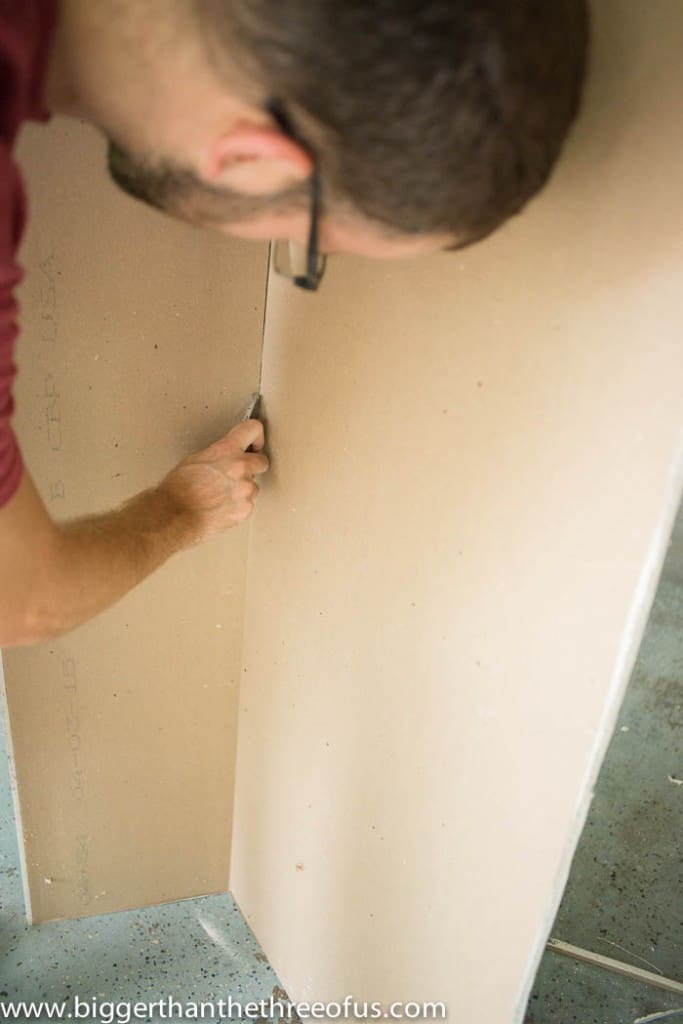 installing drywall showing cutting the drywall 