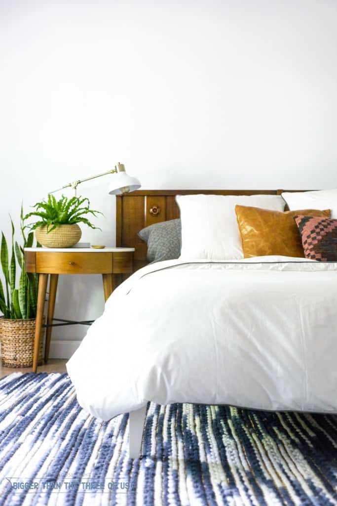 Modern Eclectic Mid-Century Bedroom with white duvet , West Elm nightstand, blue and white rug and plants