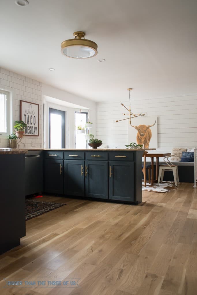 Dark blue kitchen with brass bar pulls and wood accents