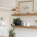 Dark blue kitchen with brass bar pulls and wood accents