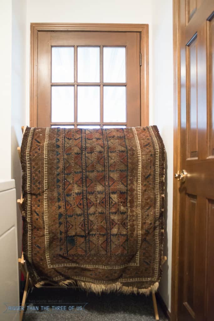 clean a vintage rug and dry it over a drying rack 