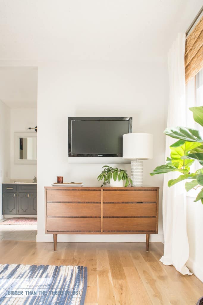 TV hanging above a mid-century vintage dresser. Come over to see more of this room. 