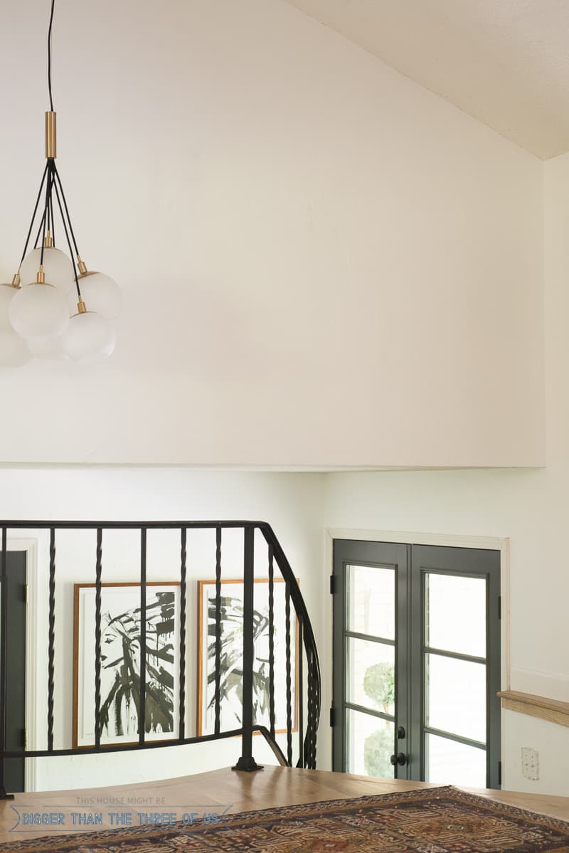 Black railing, double front doors and black interior doors in entryway 