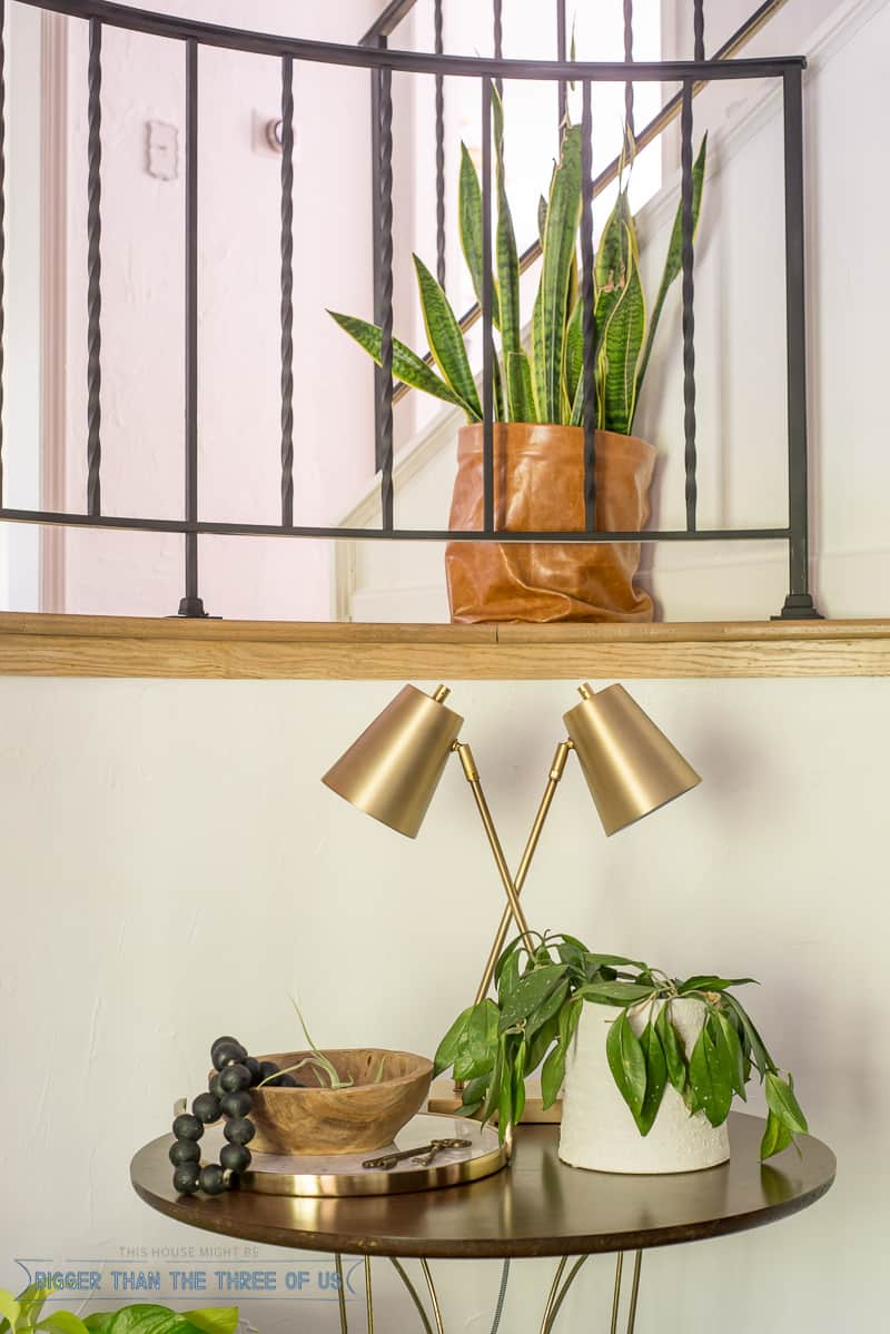 Round table in entryway with lamp and plants