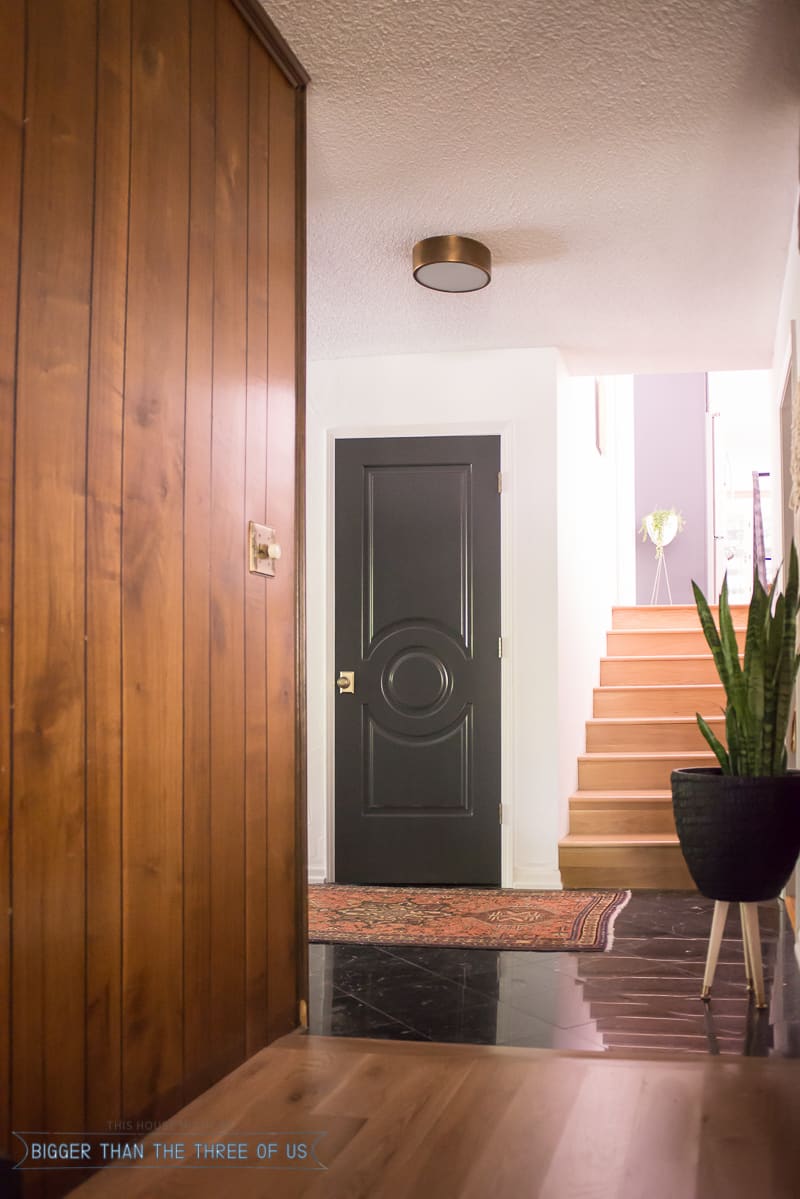 Dark interior doors with marble flooring and a vintage rug 