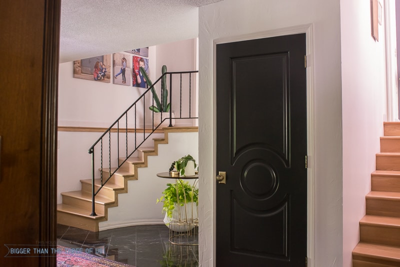 Modern Entryway with marble flooring, black doors and a vintage rug