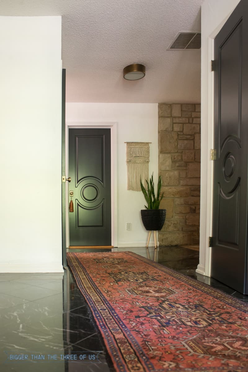 Vintage runner in entryway with black doors