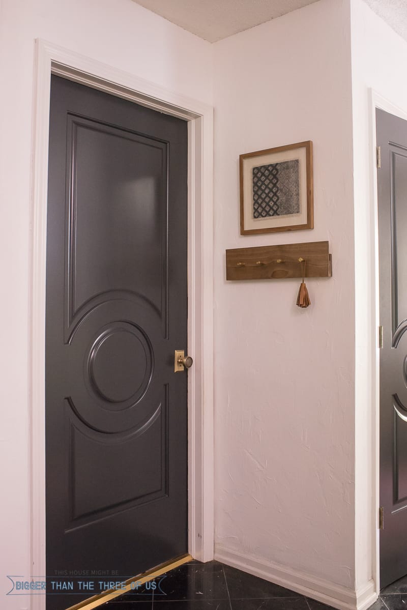 Dark doors in entryway with a modern coatrack 