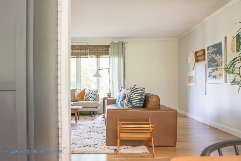 Leather couch in mid-century living room with shag rug and gallery wall 