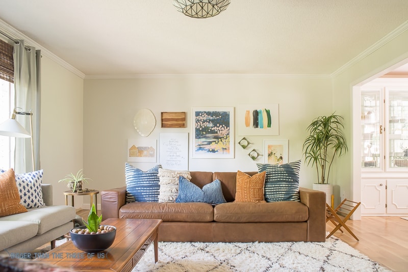 Oversized leather couch in living room with shag rug and gallery wall 