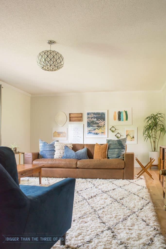 gallery wall in living room with leather sofa and shag rug 