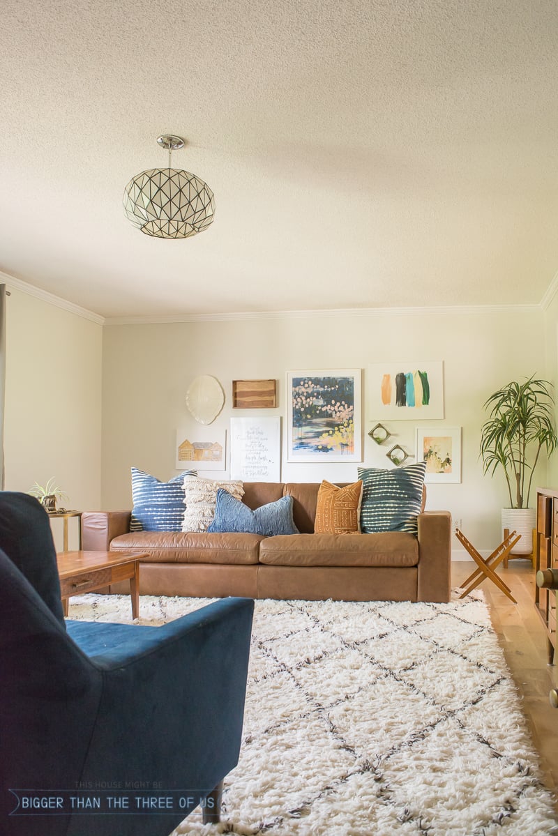 gallery wall in living room with leather sofa and shag rug