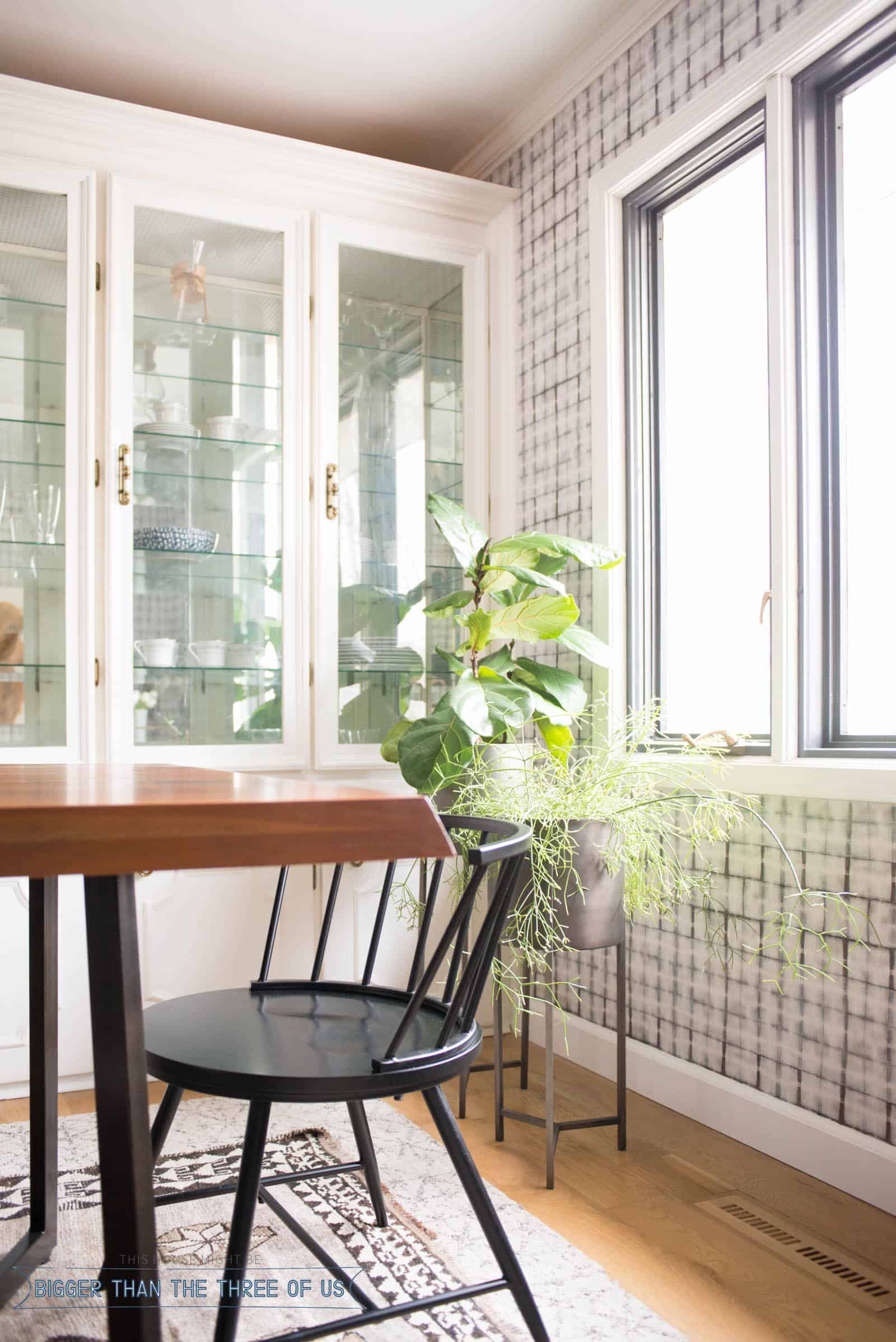 Black dining chairs in formal dining room with standing plant stands