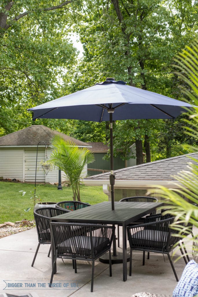 Outdoor patio space with modern black table and blue umbrella