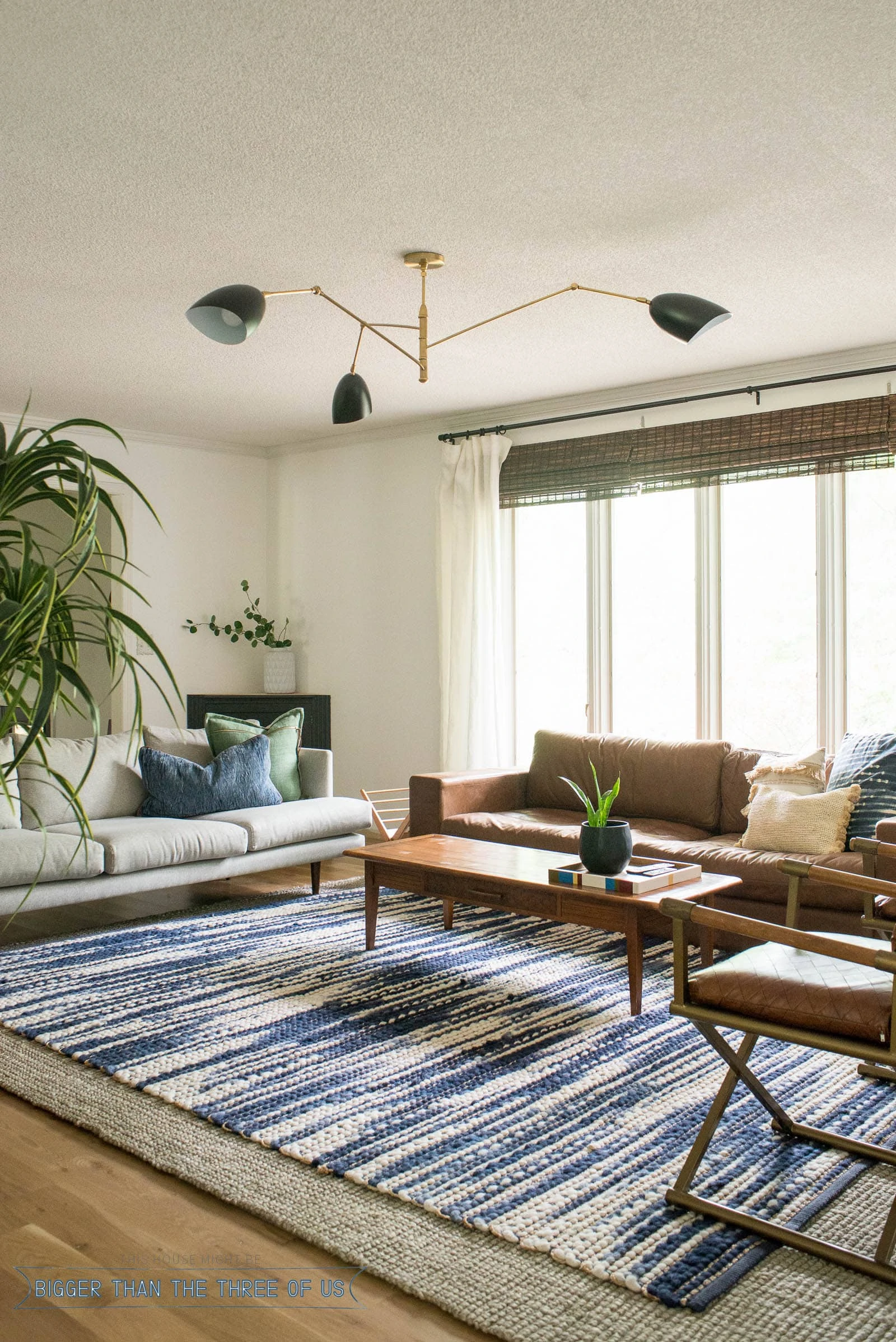 New Black and Brass light for the living room. Blue and white rug, leather couch in living room.