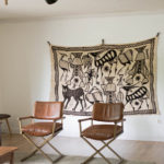 Oversized vintage textile on wall in living room.