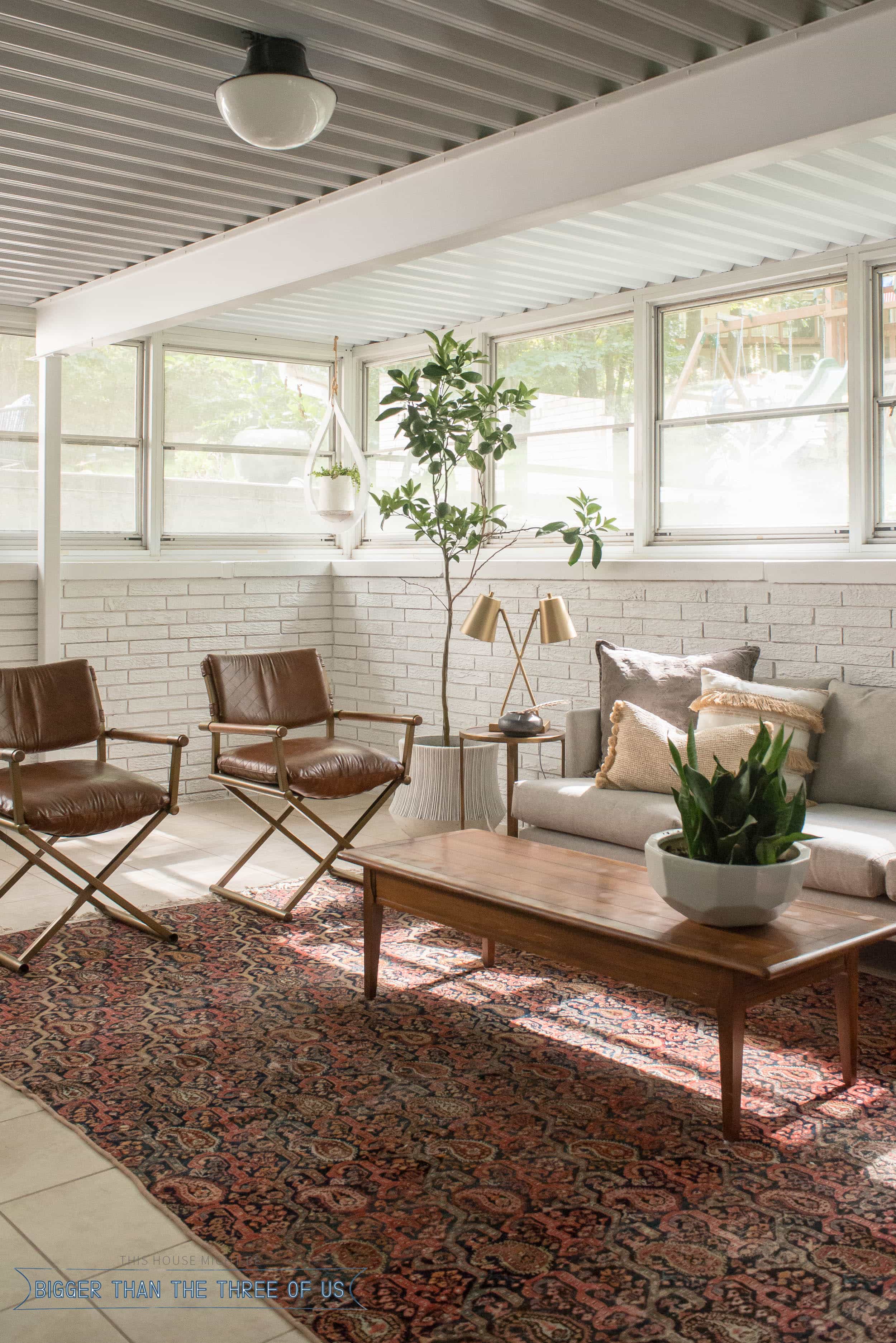 Sunroom Office at the back of the house with a vintage rug, seating space in sunroom and more!