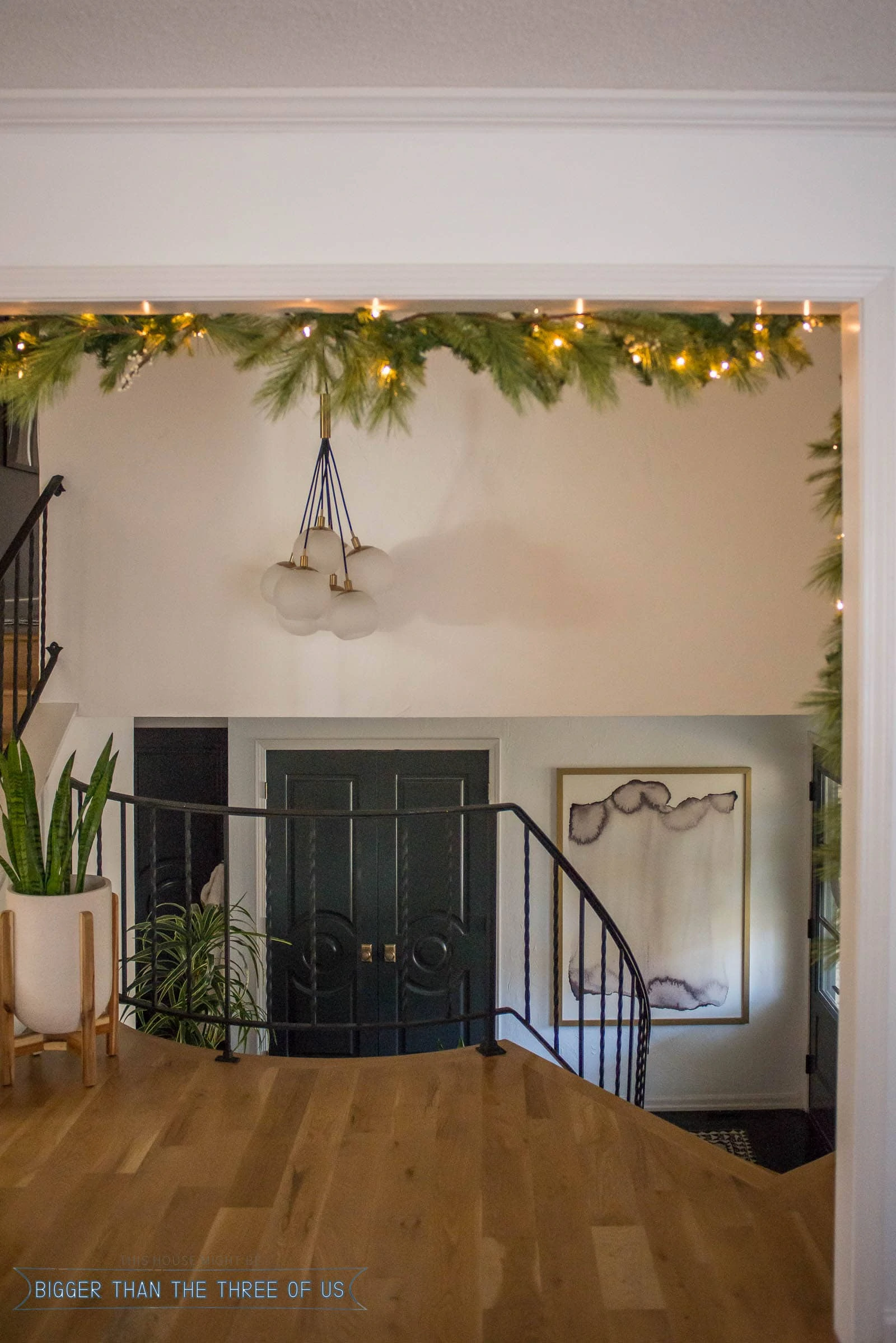 Christmas Garland hanging in doorway overlooking entryway with blue and brass accents.