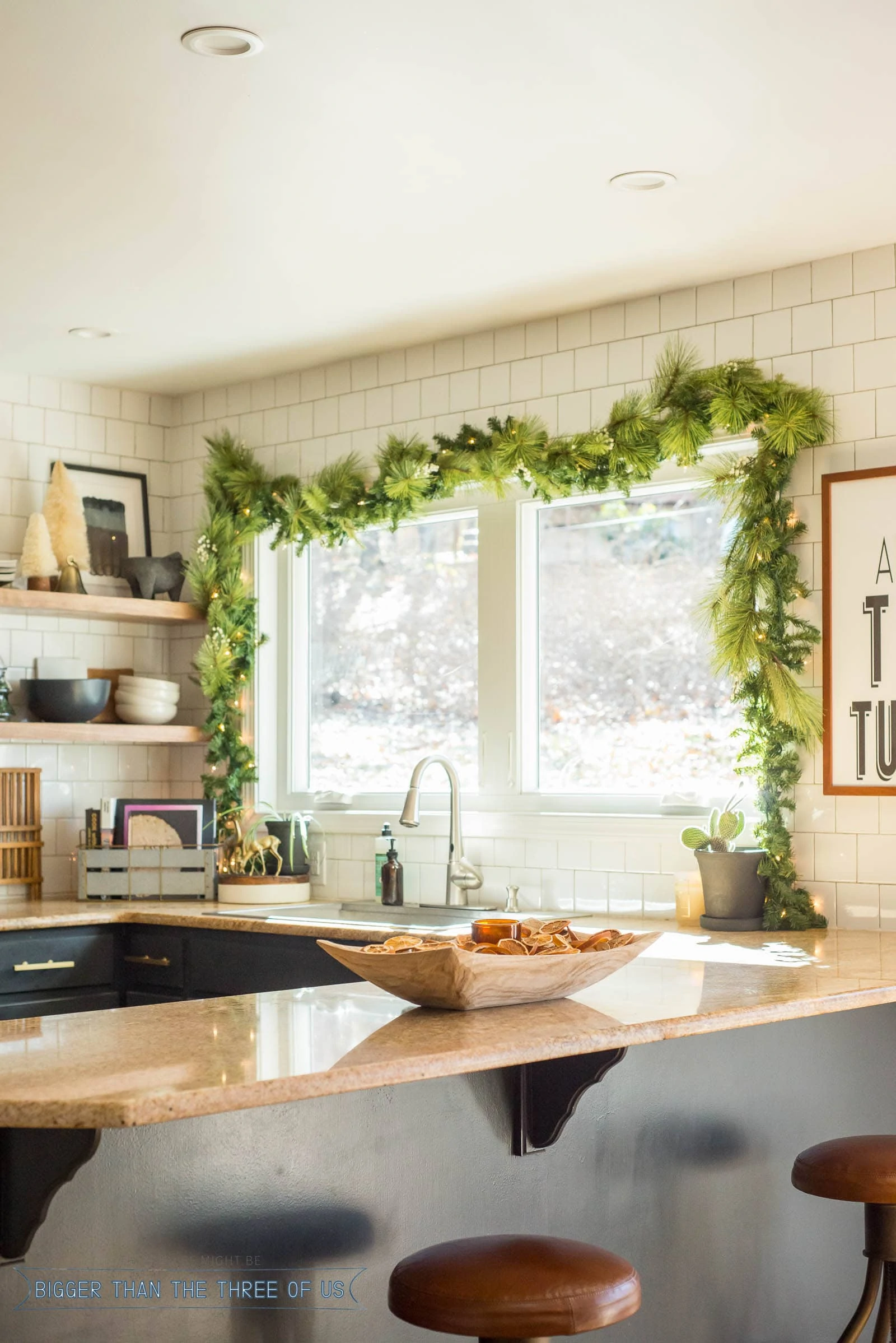 Christmas Swag over kitchen windows with dried oranges in a bowl on granite countertop