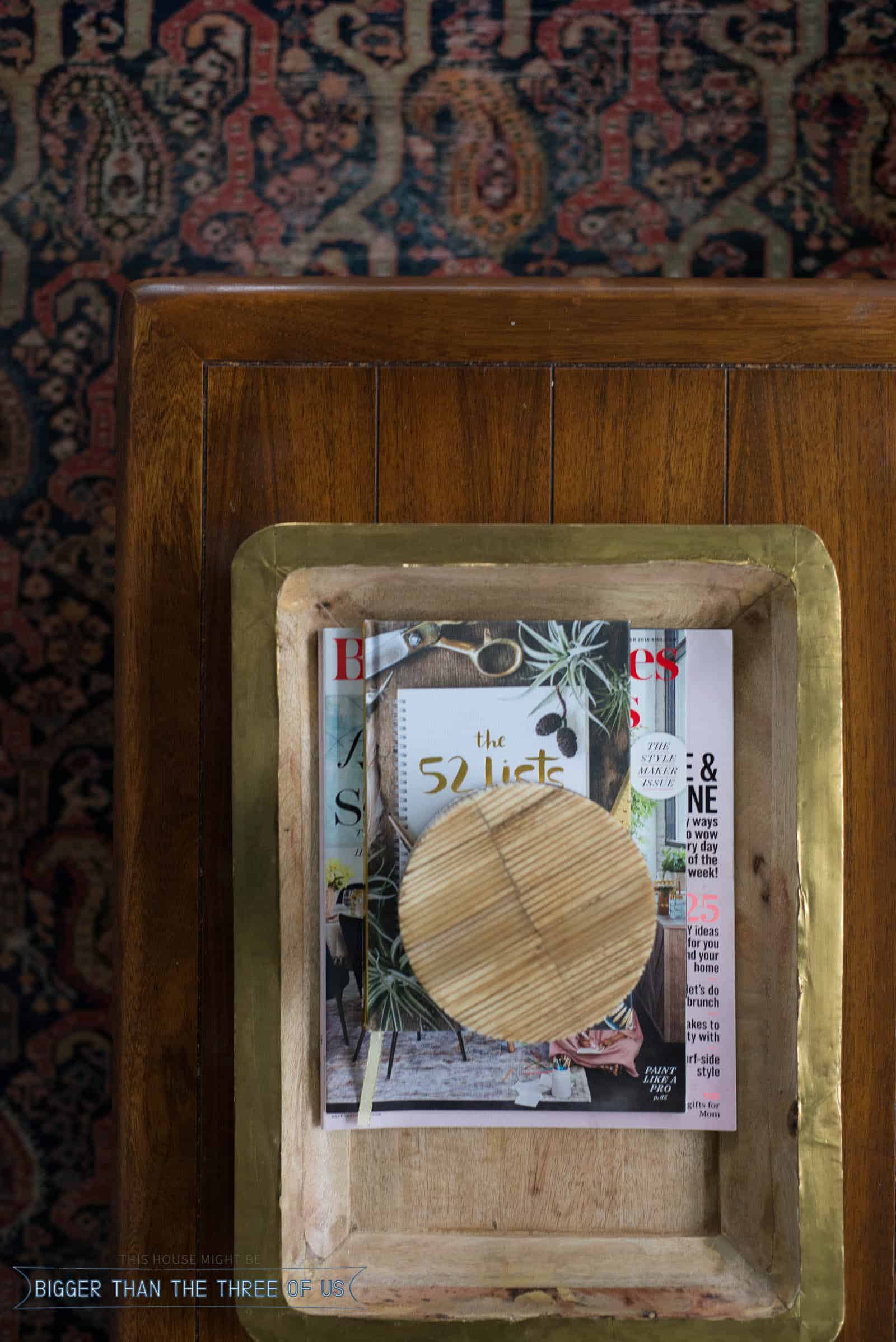 Coffee table with wood tray styled with magazines and a wood box.