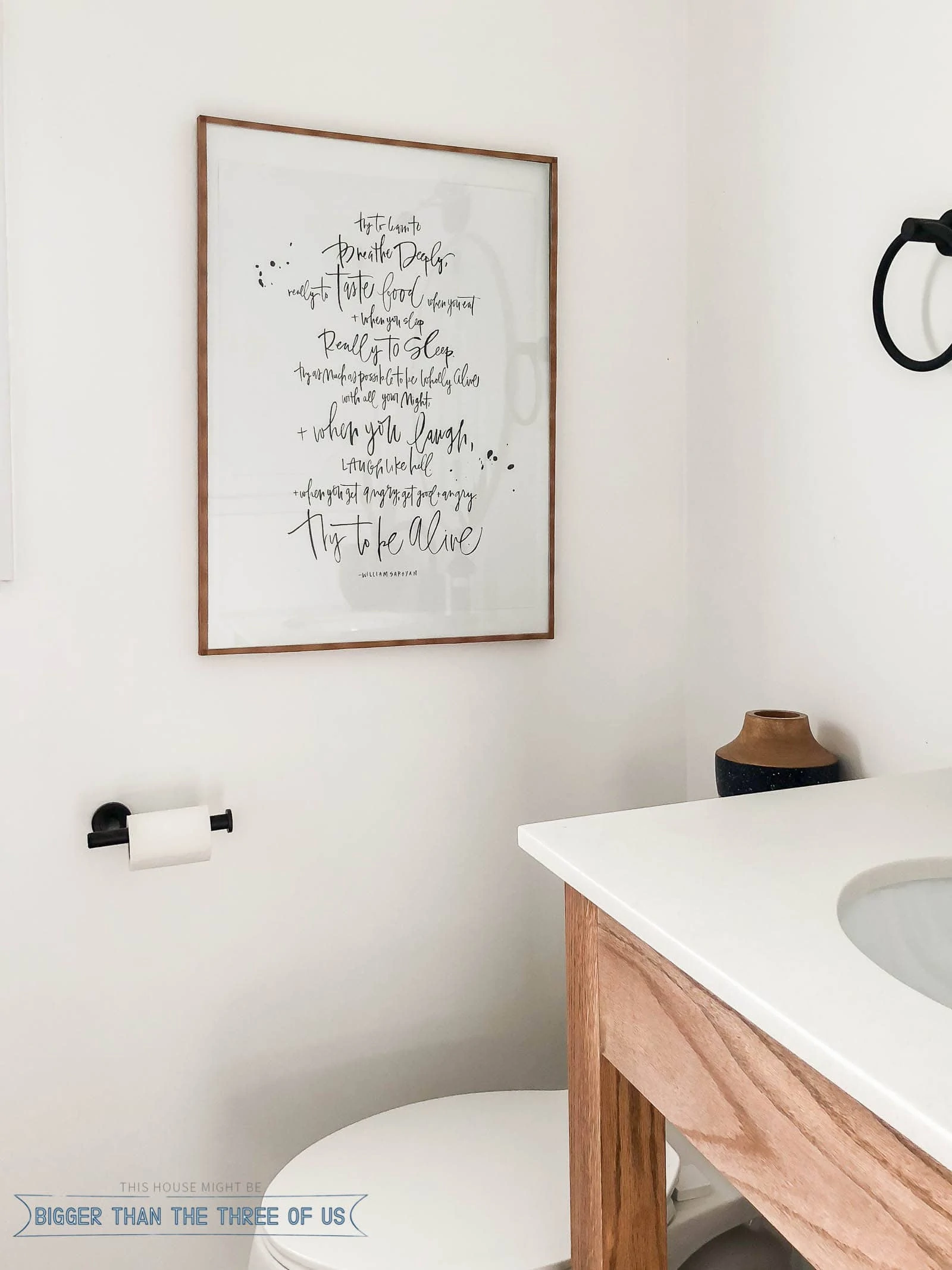 DIY wood picture frame being shown on white wall in bathroom.