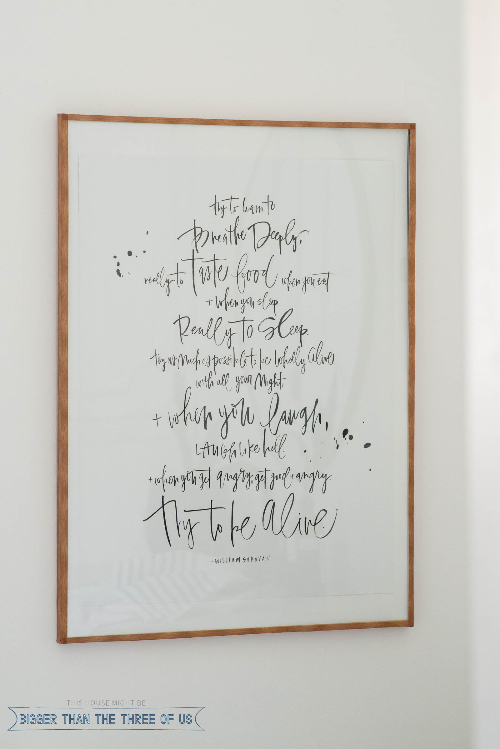 Closeup of poster frame hack featuring a metal frame transformed with wood grain tape.