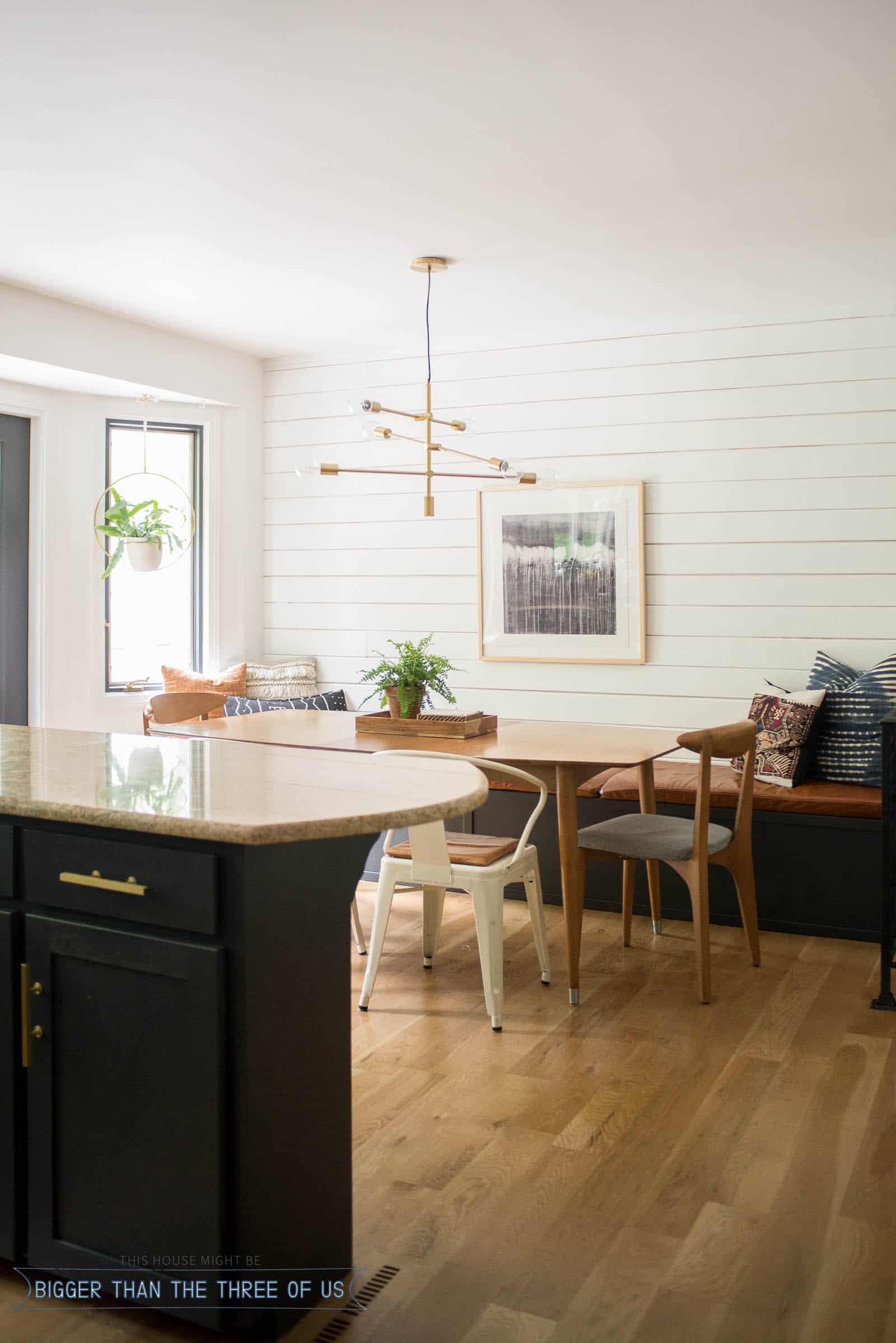 Eat In Kitchen with white modern wood wall treatment, leather bench and mid-century furniture. 