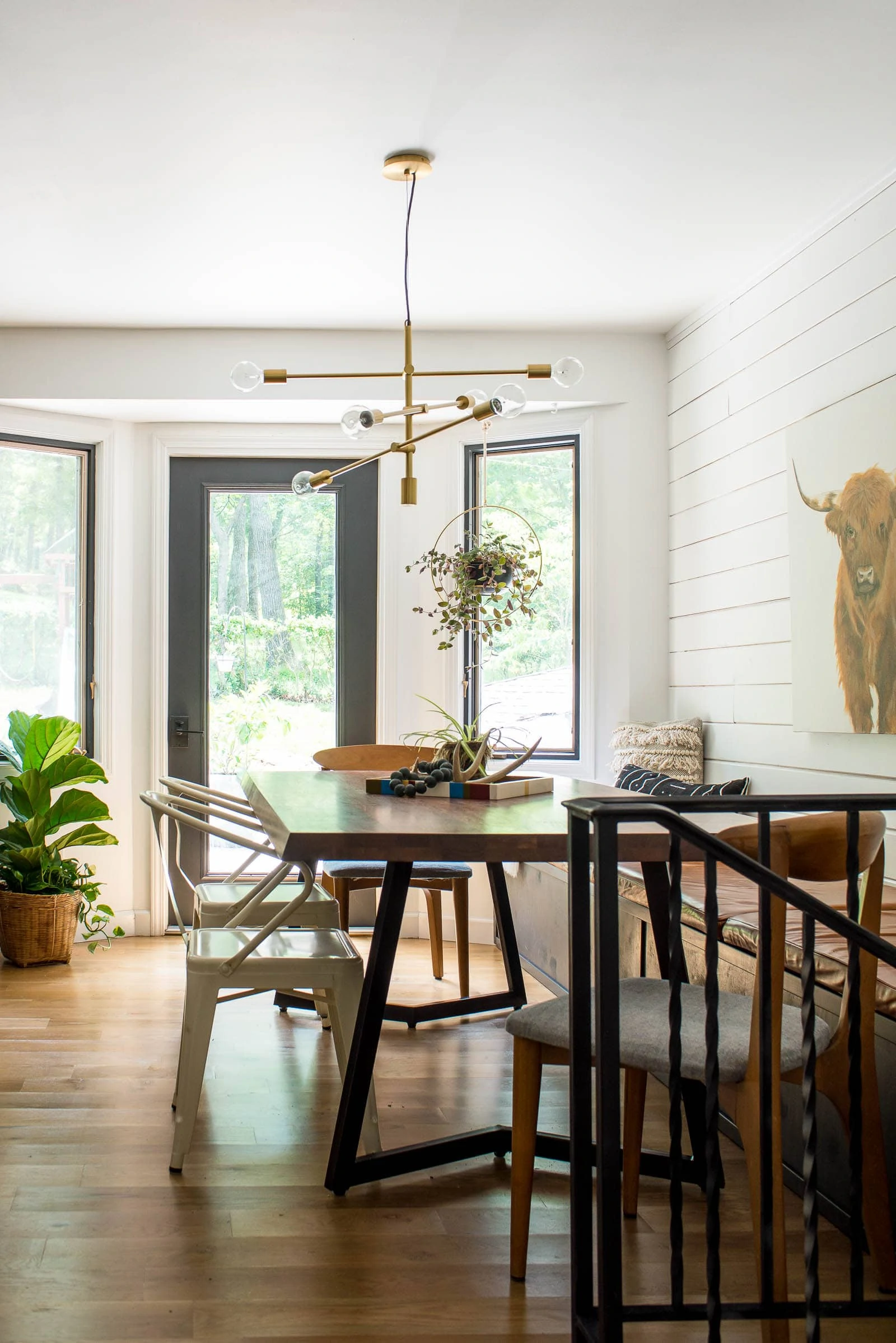 Eclectic eating space with shiplap, wood floors and a dining room table