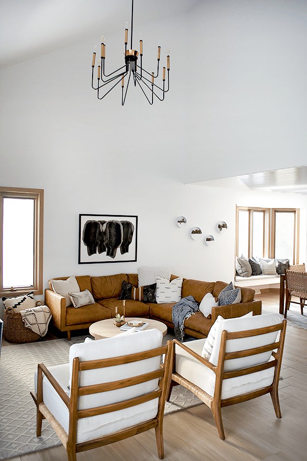 Brown leather sectional in a white and light living room. 