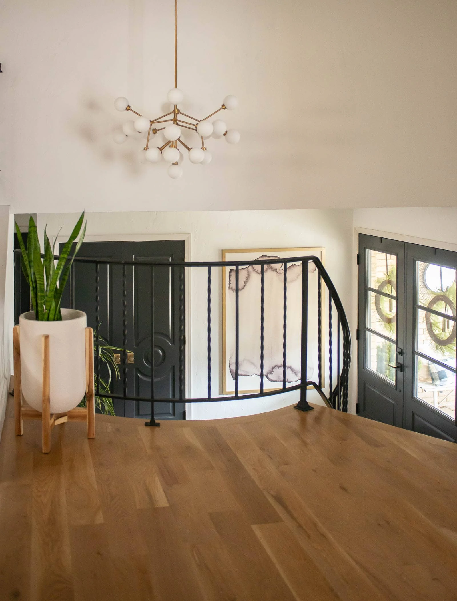 View of entryway with double front doors, stairs and art. 