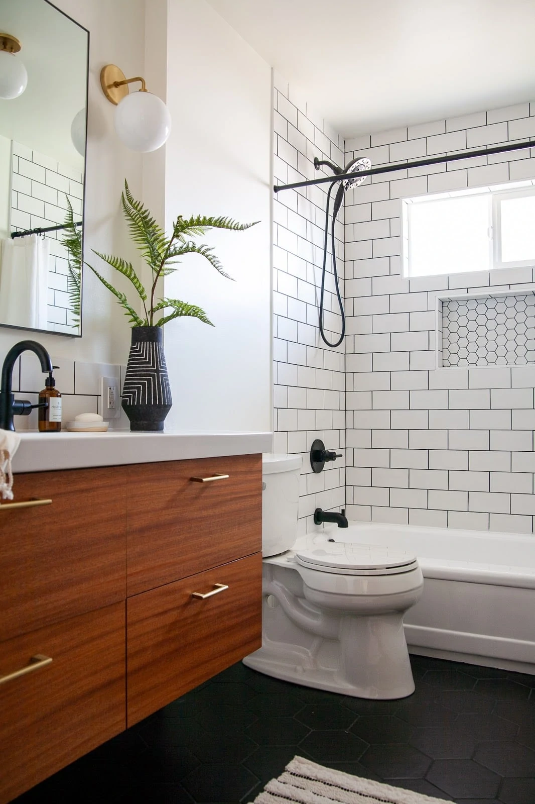 Midcentury inspired bathroom with oversized tile in shower and a wood cabinet