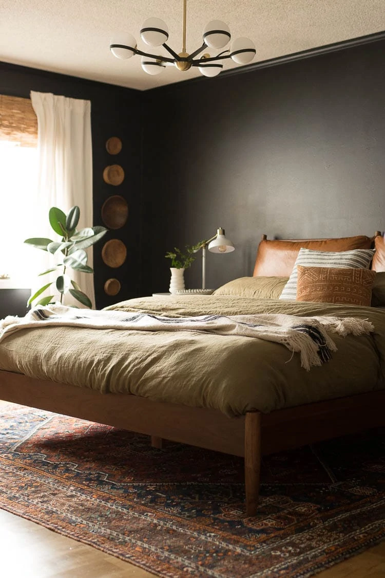 Vintage Wooden Bowls on Wall in painted black bedroom with midcentury furniture