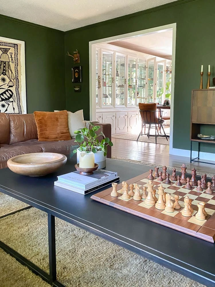 coffee table styled with chess board, plant and books in living room