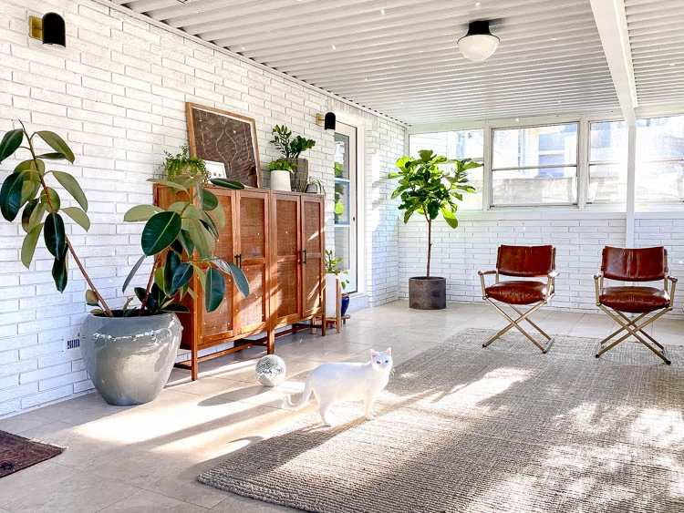 White brick in sunroom with plants and storage