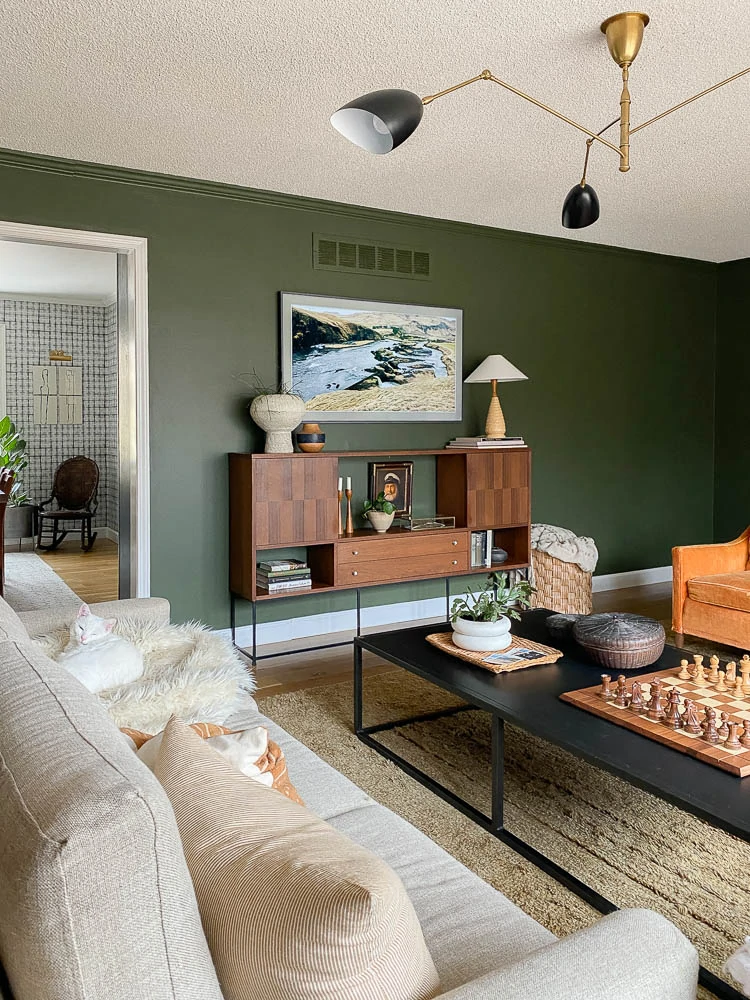 eclectic living room with a wood media console with shelving under the tv