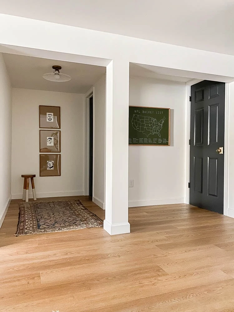 Football map stadium art piece in basement on white walls with light colored wood flooring