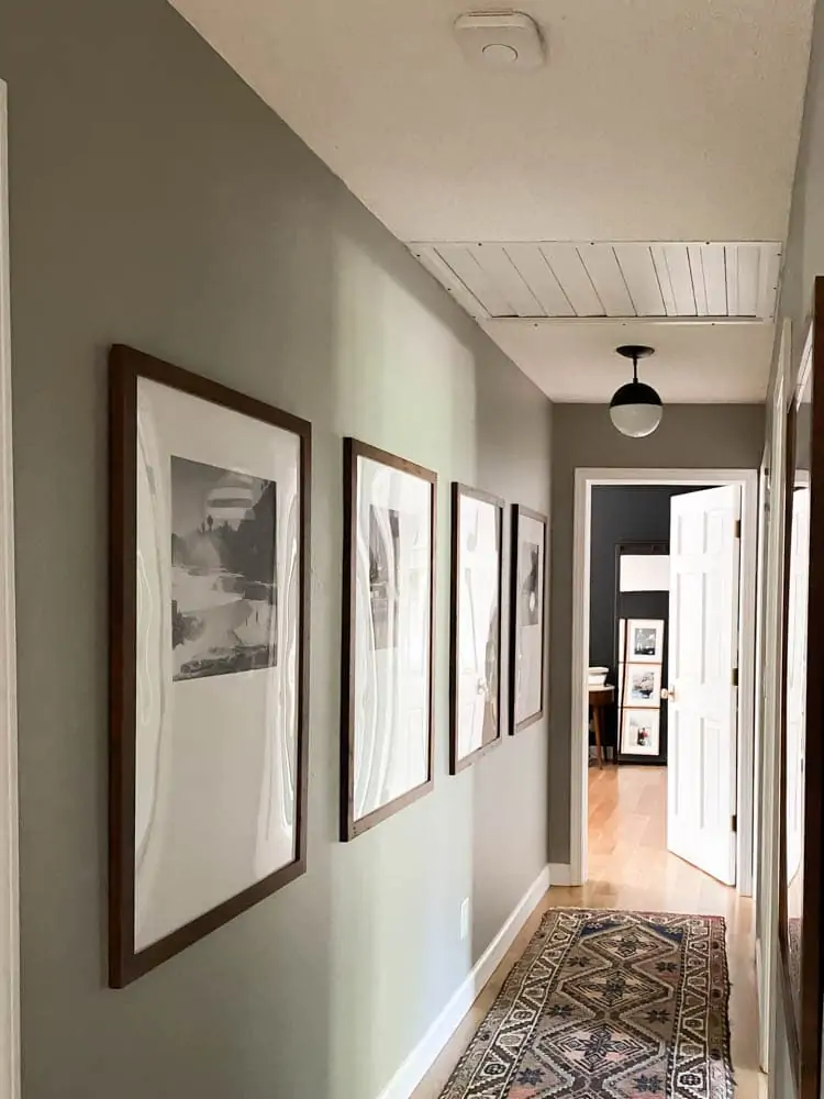 Nest Smoke Alarms are a great smart home automation tool. Showing the nest in a hallway with modern brown poster frames hanging. 