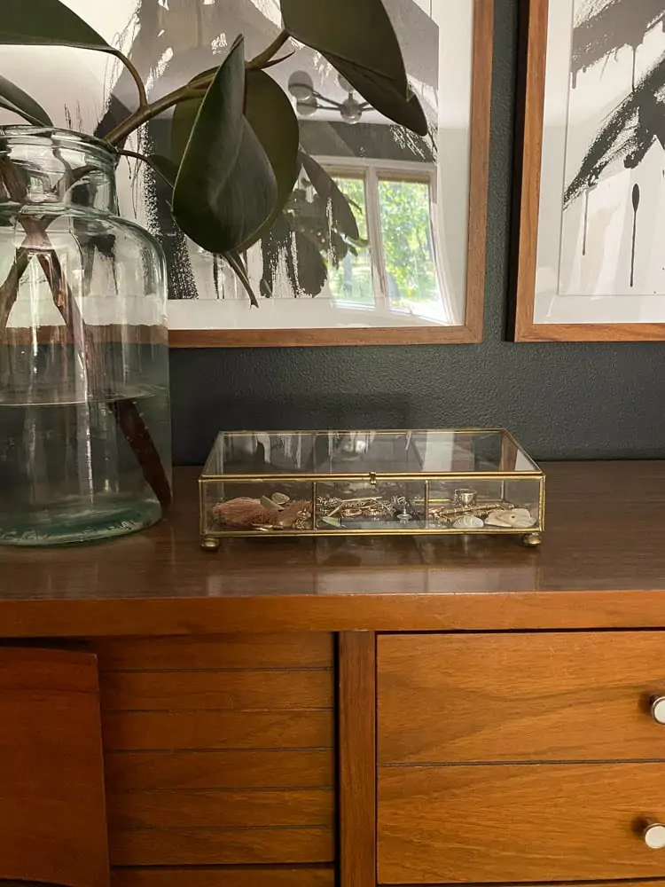 jewelry organizer ideas including a brass and glass small jewelry organizer sitting on a dresser in the bedroom