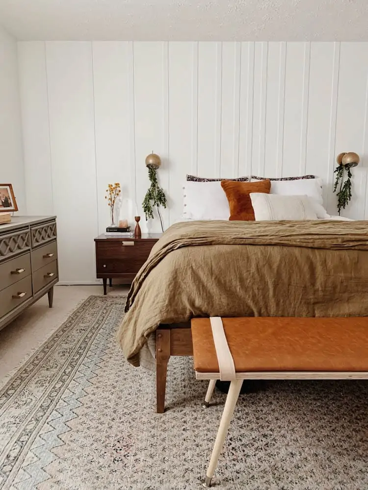 Minimalist Christmas decor in bedroom with greenery hanging from lights