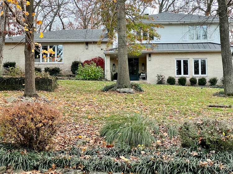 original cream brick and white siding exterior of a split level house from the 70s