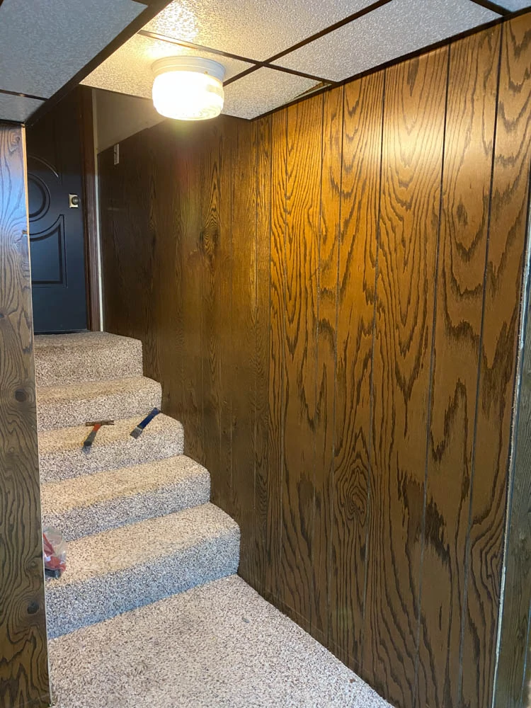 Basement Stairs BEFORE photo with carpet stairs and 70s wood paneling