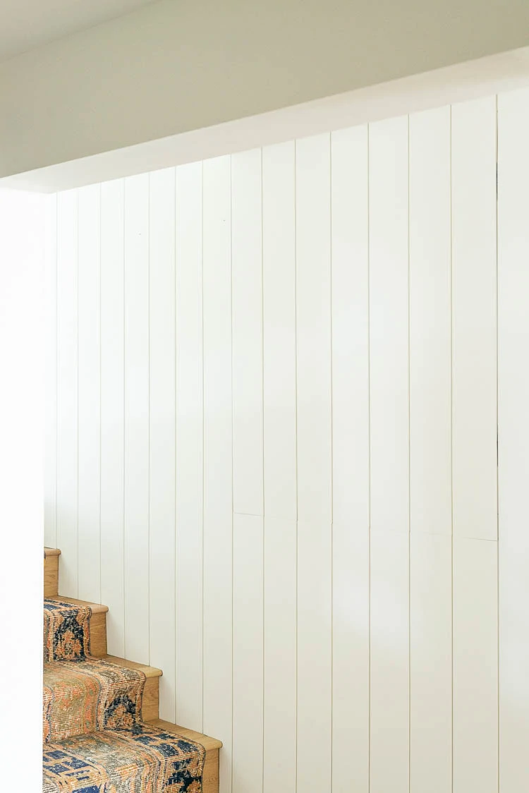 Building A Hidden Door In A Wall showing a door with wall paneling that hides a secret passage under stairs