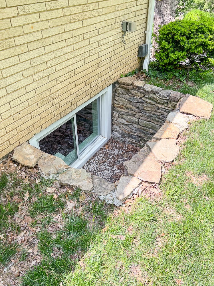 stacked stone window well around basement egress window