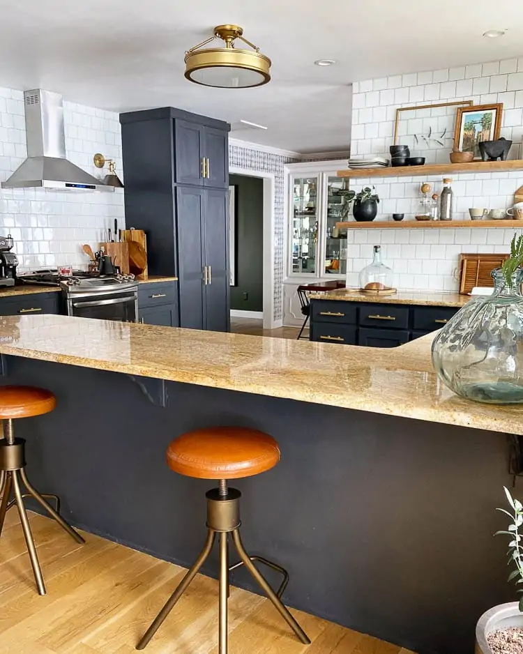 Kitchen with dark blue cabinets and wood shelving