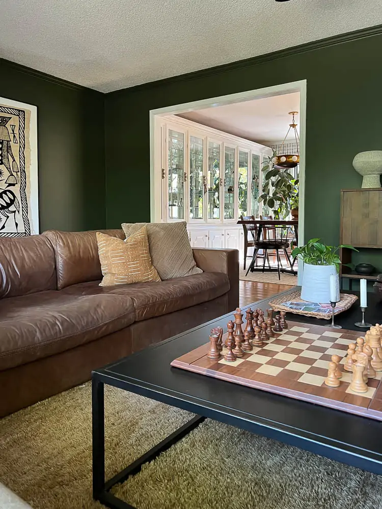 leather couch and black coffee table with dark green paint room