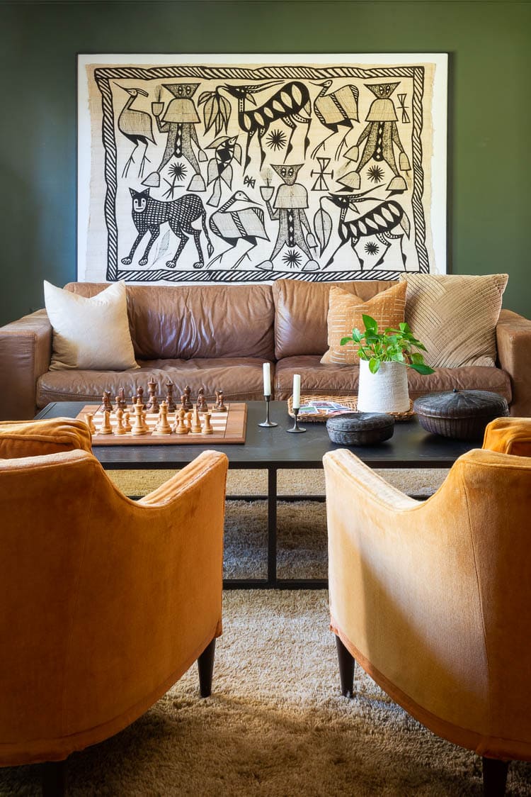 oversized African textile art in living room with leather sofa in front of art 