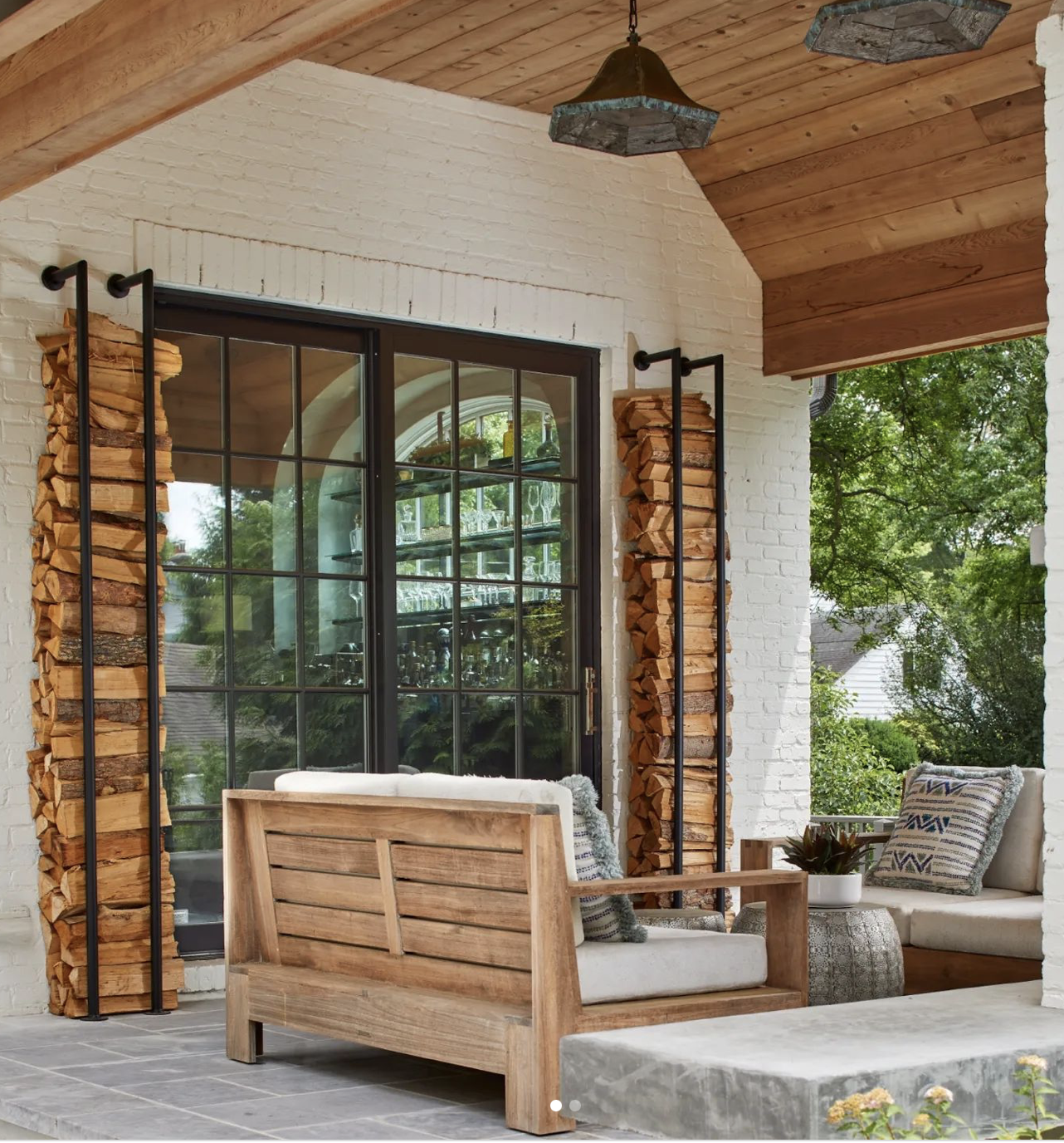 outdoor firewood storage ideas with this one featuring vertical storage on the patio 