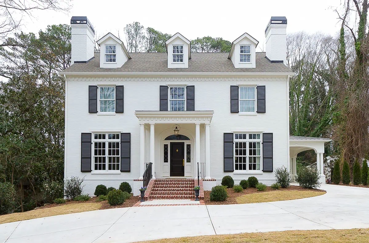 traditional home with white brick and red brick porch 